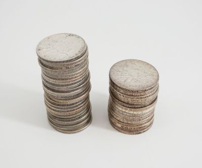two stacks of coins sitting next to each other on a white surface