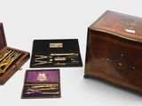 several different types of items are in a wooden box on a white surface