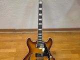 an electric guitar sitting on top of a wooden floor next to a wall