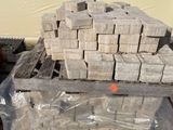 un tas de briques posé sur une palette à côté d'un bâtiment