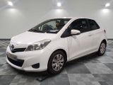 la toyota yaris blanche est garée sur un carrelage à carreaux