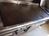 a stainless steel stove top in a kitchen with tile flooring