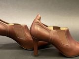 a close up of a pair of brown shoes on a gray surface