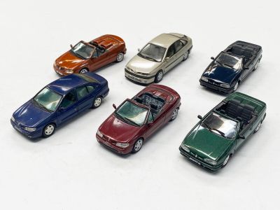 plusieurs petites voitures sont alignées sur une surface blanche