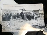 a black and white photo of a group of people standing in the sand