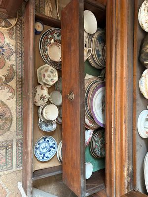 une armoire en bois sur laquelle sont posées des assiettes, dans une pièce