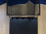 an overhead view of a blue umbrella with a glass shelf underneath it