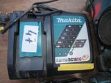 a makitta charger and a corded driller on a table