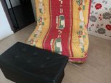 un fauteuil-futon et un repose-pieds dans un coin de la pièce