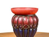 a red and blue vase sitting on a wooden table