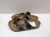 pair of black sandals on a white surface with a white background