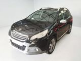 La petite voiture noire est garée dans une pièce blanche.