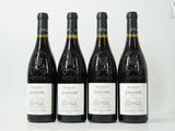 quatre bouteilles de vin sont alignées sur une surface blanche