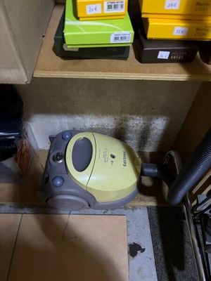 un aspirateur posé sur le sol à côté d'une boîte