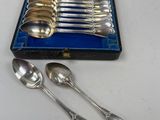 silverware in a blue case with spoons and spoons on a table