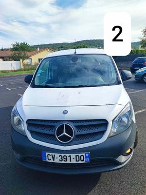 une camionnette blanche garée sur un parking, avec le chiffre 2 à l'avant