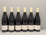 six bouteilles de vin sont alignées sur une table