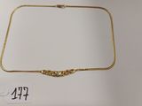 un collier en or orné d'un nœud et muni d'une étiquette de prix
