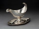 une assiette en argent sur laquelle repose une soucoupe en argent