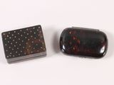 pair of tortoise shell cigarette cases on a white surface