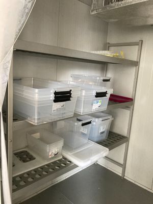 de nombreux récipients en plastique posés sur les étagères de la cuisine