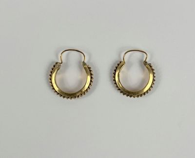 une paire de boucles d'oreilles en or sur fond blanc