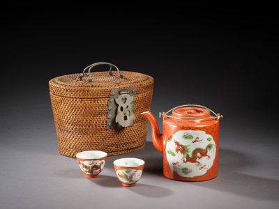 deux tasses et une théière sont posées à côté d'un panier