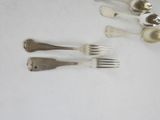 five silver spoons and two silver spoons on a white table