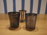 two silver cups sitting on a table next to each other