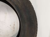 a close up of a tire on a white surface next to a white wall