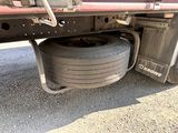 a truck with a tire that is sitting on the side of the road