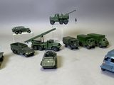 plusieurs véhicules militaires miniatures et une tour radio posés sur une surface blanche