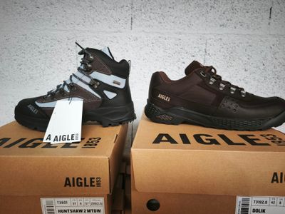 deux paires de chaussures de randonnée pour homme posées sur des cartons