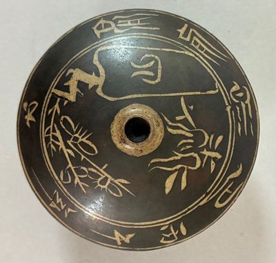 a black and gold plate with asian writing on it