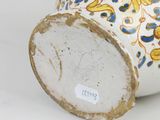 a white vase with a blue and yellow design on it