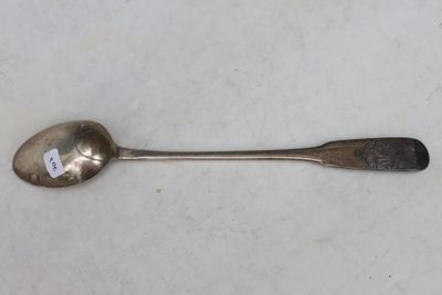 an old spoon sitting on top of a table next to a small spoon