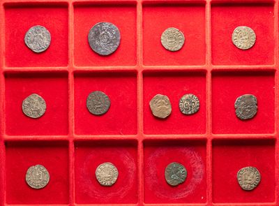 an assortment of ancient roman coins in a red display case