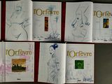 six books with drawings of women on them on a table