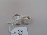 two wedding rings and a price tag on a table