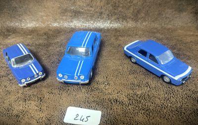 trois voitures jouets assises l'une à côté de l'autre sur une table