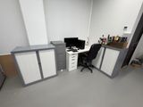 une pièce équipée d'un bureau, d'armoires et d'un ordinateur posé dessus