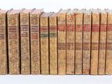 plusieurs vieux livres sont empilés sur une surface blanche