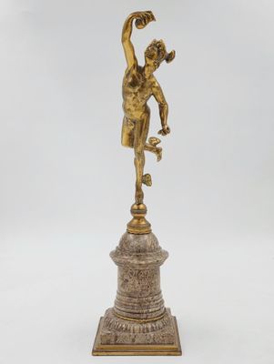 une figurine antique en bronze représentant un garçon sur un socle