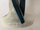 a white vase with a black handle on a white table