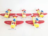 several small toy airplanes are lined up on a white surface