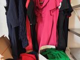 beaucoup de vêtements suspendus à une étagère dans une pièce