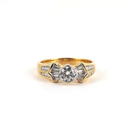 une bague en or jaune sertie d'un diamant et de diamants taille baguette
