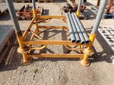 a pile of pipes sitting on the ground next to a pile of other pipes