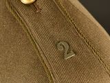 the back of a brown jacket with a gold button on it