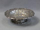 a silver bowl on a silver stand on a table